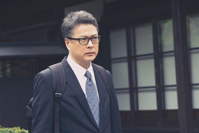 スマホを持たない超アナログな人形供養の専門家・神田を演じる