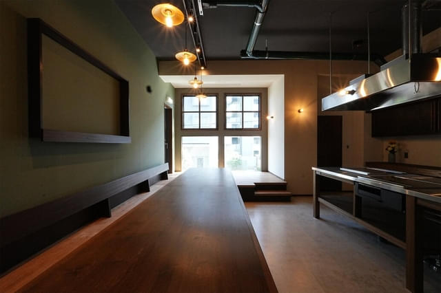 シェアハウスのキッチン、リビングの共有部。ドア外には映画館のスクリーンが