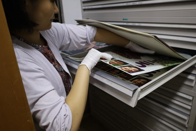 （画像上：2点）B2サイズのポスター出庫の様子。下にあるポスターは無理に引っ張ると破れる危険性がある。上のポスターの重さがかからないようにして取り出す