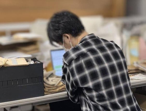 収蔵庫内で黙々とカタロギング作業をしている豊福さん