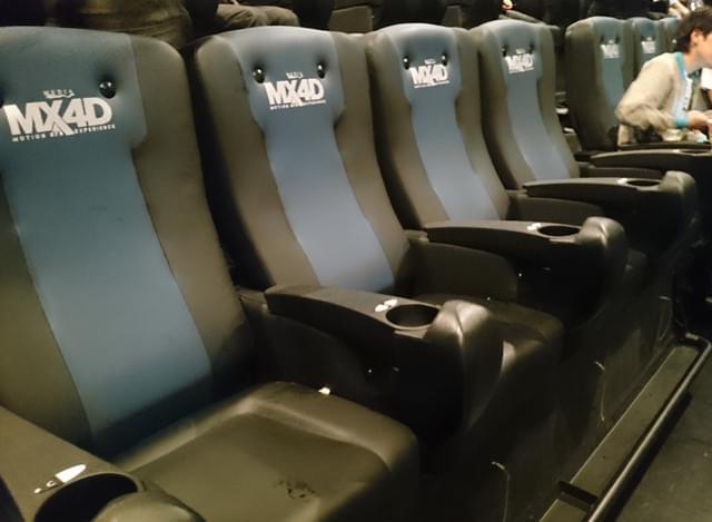 MX4Dのシート。ドリンクホルダーの前に水と風の噴出口がある。 足元に垂れ下っている白い紐は、 ときたま暴れ出して観客をビクッとさせるイタズラ者。