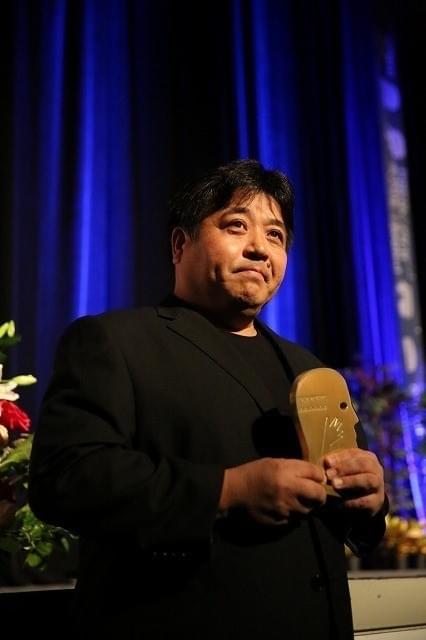 トロフィーを受け取った錦織良成監督