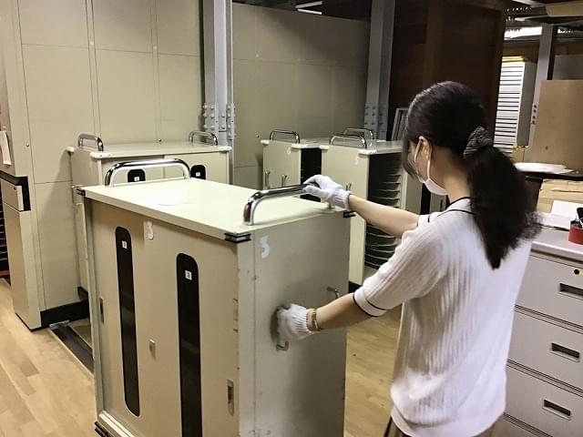 フィルムを積み重ねずに運べるフィルム専用台車、通称“ニッシャー”を京橋本館から運び出す根本里奈さん