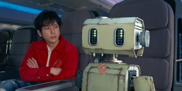 冒険の始まり、飛行機で移動する健（二宮和也）＆ポンコツロボット“タング”