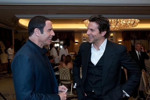 歓談するジョン・トラボルタとブラッドリー・クーパー