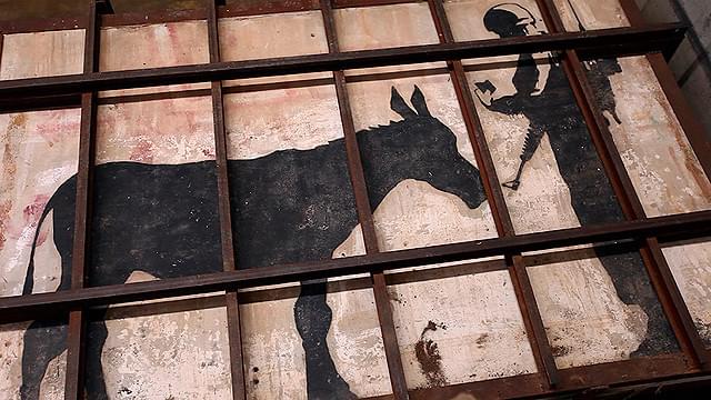 覆面アーティストのバンクシーが描いた「ロバと兵士」