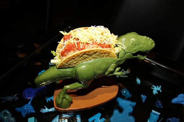 「ジュラシック・パーク」のT-REXを彷ふつとさせる恐竜形の容器に載ったタコス「TACO-REX」