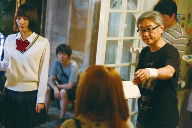 撮影現場で演出中の堤監督（右）