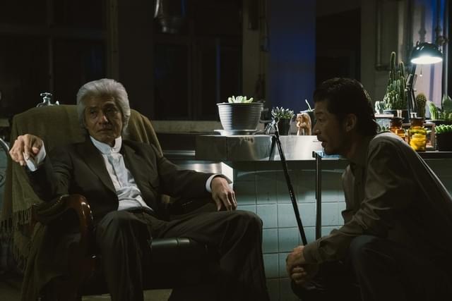 佐藤浩市(左:軍医役)と浅野忠信(右:ニセ医者役)