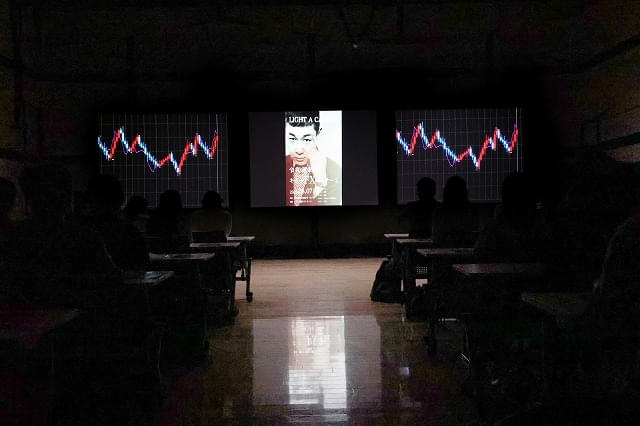 金融商品の価格変動を表した、色鮮やかな“キャンドルスティック”が映る劇中シーン