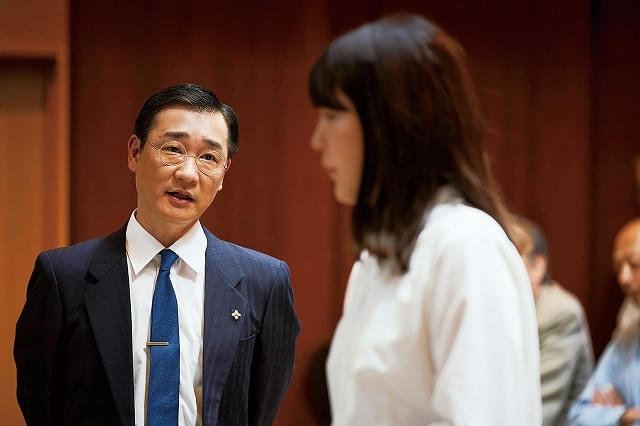 サチへの尋問を行う検事・時田（安井順平）