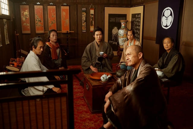 総一郎と「森田座」の面々。右手前に座すのが、芝居小屋全体を取り仕切る立作者の篠田金治（演：渡辺謙）